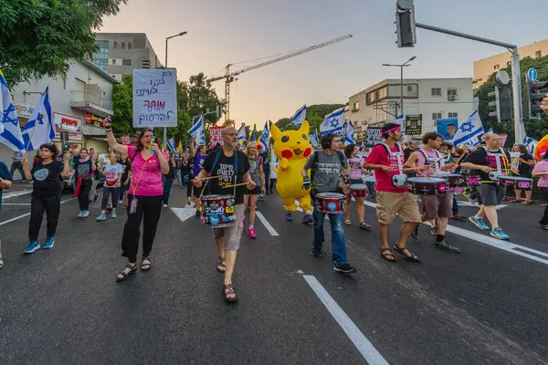 Hayfa, İsrail - Haziran 07, 2025: İnsanlar (Pikachu kostümlü adamla birlikte) savaşın sona ermesi, rehine anlaşmasının tamamlanması ve yeni seçimler çağrısında bulunan bir protesto yürüyüşüne katılıyor. Hayfa, İsrail