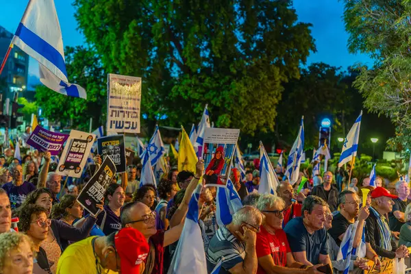 Hayfa, İsrail - 7 Haziran 2025: Çeşitli tabela ve bayraklara sahip bir kalabalık, savaşın sona ermesi, rehine anlaşmasının tamamlanması ve yeni seçimler için düzenlenen protesto mitingine katıldı. Hayfa, İsrail