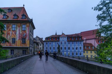 Bamberg, Almanya - 07 Ekim 2024: Bamberg, Bavyera, Almanya 'da çeşitli bina, yerli ve ziyaretçilerle Untere Brucke (aşağı köprü) manzarası