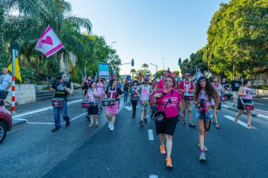 Hayfa, İsrail - 28 Haziran 2025: İnsanlar savaşın sona ermesi, rehine anlaşmasının tamamlanması ve yeni seçimler çağrısında bulunan bir protesto yürüyüşüne (Pembe Cephe Grubu) katılıyor. Hayfa, İsrail