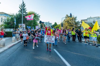 Hayfa, İsrail - 28 Haziran 2025: İnsanlar savaşın sona ermesi, rehine anlaşmasının tamamlanması ve yeni seçimler çağrısında bulunan bir protesto yürüyüşüne (Pembe Cephe Grubu) katılıyor. Hayfa, İsrail