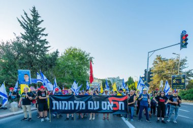 Hayfa, İsrail - 28 Haziran 2025: Çeşitli tabelaları ve bayrakları olan insanlar, savaşın sona ermesi, rehine anlaşmasının tamamlanması ve yeni seçimlerin başlatılması için düzenlenen protesto mitingine katıldılar. Hayfa, İsrail