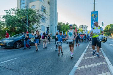 Hayfa, İsrail - 28 Haziran 2025: Çeşitli tabelaları ve bayrakları olan insanlar, savaşın sona ermesi, rehine anlaşmasının tamamlanması ve yeni seçimlerin başlatılması için düzenlenen protesto mitingine katıldılar. Hayfa, İsrail