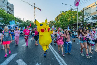 Hayfa, İsrail - 28 Haziran 2025: İnsanlar (Pikachu kostümlü adamla birlikte) savaşın sona ermesi, rehine anlaşmasının tamamlanması ve yeni seçimler çağrısında bulunan bir protesto yürüyüşüne katılıyor. Hayfa, İsrail