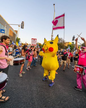 Hayfa, İsrail - 28 Haziran 2025: Davul çemberi, Pikachu kostümlü bir adamla, Hayfa, İsrail 'deki bir protesto mitinginin bir parçası