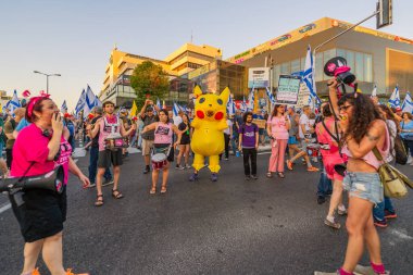Hayfa, İsrail - 28 Haziran 2025: Davul çemberi, Pikachu kostümlü bir adamla, Hayfa, İsrail 'deki bir protesto mitinginin bir parçası