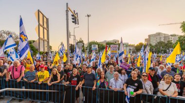 Hayfa, İsrail - 28 Haziran 2025: Çeşitli tabela ve bayraklara sahip bir grup insan, savaşın sona ermesi, rehine anlaşmasının tamamlanması ve yeni seçimler için düzenlenen protesto mitingine katıldı. Hayfa, İsrail