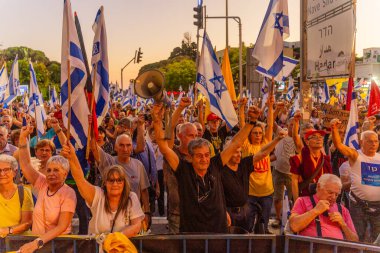 Hayfa, İsrail - 28 Haziran 2025: Çeşitli tabela ve bayraklara sahip bir grup insan, savaşın sona ermesi, rehine anlaşmasının tamamlanması ve yeni seçimler için düzenlenen protesto mitingine katıldı. Hayfa, İsrail