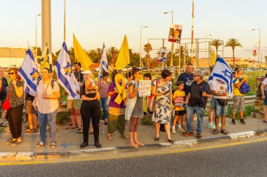 Ein HaMifratz, İsrail - 3 Temmuz 2025: Rehine posterleri ve diğer tabelaları olan insanlar, otoyolun yakınında, rehinelere destek çağrısında bulunuyorlar ve anlaşmanın tamamlanmasını istiyorlar, Ein HaMifratz, İsrail