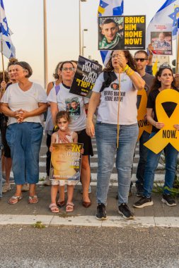 Ein HaMifratz, İsrail - 3 Temmuz 2025: Rehine posterleri ve diğer tabelaları olan insanlar, otoyolun yakınında, rehinelere destek çağrısında bulunuyorlar ve anlaşmanın tamamlanmasını istiyorlar, Ein HaMifratz, İsrail