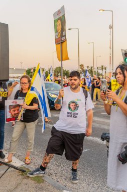 Ein HaMifratz, İsrail - 3 Temmuz 2025: Rehine posterleri ve diğer tabelaları olan insanlar, otoyolun yakınında, rehinelere destek çağrısında bulunuyorlar ve anlaşmanın tamamlanmasını istiyorlar, Ein HaMifratz, İsrail