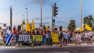 Ein HaMifratz, İsrail - 3 Temmuz 2025: Rehine posterleri ve diğer tabelaları olan insanlar, otoyolun yakınında, rehinelere destek çağrısında bulunuyorlar ve anlaşmanın tamamlanmasını istiyorlar, Ein HaMifratz, İsrail