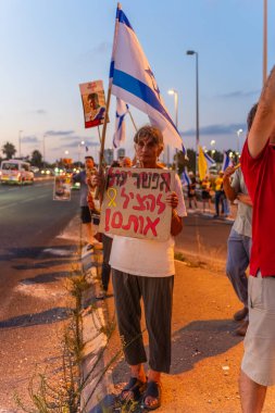 Ein HaMifratz, İsrail - 3 Temmuz 2025: Rehine posterleri ve diğer tabelaları olan insanlar, otoyolun yakınında, rehinelere destek çağrısında bulunuyorlar ve anlaşmanın tamamlanmasını istiyorlar, Ein HaMifratz, İsrail