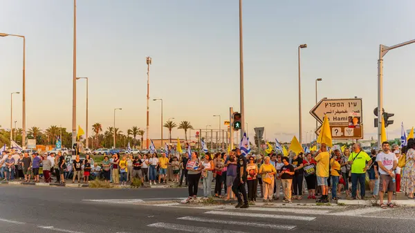 Ein HaMifratz, İsrail - 3 Temmuz 2025: Rehine posterleri ve diğer tabelaları olan insanlar, otoyolun yakınında, rehinelere destek çağrısında bulunuyorlar ve anlaşmanın tamamlanmasını istiyorlar, Ein HaMifratz, İsrail