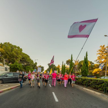 Hayfa, İsrail - Temmuz 05, 2025: İnsanlar savaşın sona ermesi, rehine anlaşmasının tamamlanması ve yeni seçimler çağrısında bulunan bir protesto yürüyüşüne (Pembe Cephe Grubu) katılıyor. Hayfa, İsrail