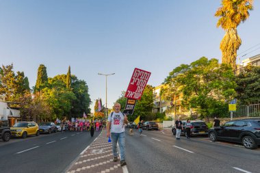 Hayfa, İsrail - Temmuz 05, 2025: Çeşitli tabela ve bayraklara sahip insanlar, savaşın sona ermesi, rehine anlaşmasının tamamlanması ve yeni seçimlerin başlatılması için düzenlenen protesto mitingine katıldılar. Hayfa, İsrail