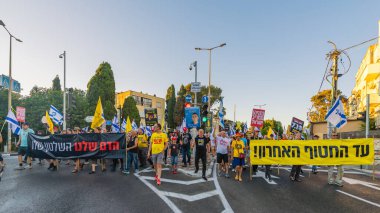 Hayfa, İsrail - Temmuz 05, 2025: Çeşitli tabela ve bayraklara sahip insanlar, savaşın sona ermesi, rehine anlaşmasının tamamlanması ve yeni seçimlerin başlatılması için düzenlenen protesto mitingine katıldılar. Hayfa, İsrail