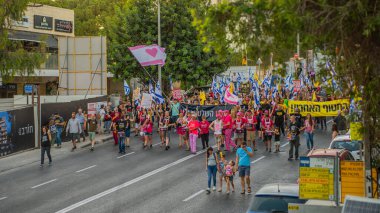 Hayfa, İsrail - Temmuz 05, 2025: İnsanlar savaşın sona ermesi, rehine anlaşmasının tamamlanması ve yeni seçimler çağrısında bulunan bir protesto yürüyüşüne (Pembe Cephe Grubu) katılıyor. Hayfa, İsrail