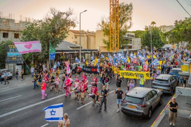 Hayfa, İsrail - Temmuz 05, 2025: İnsanlar savaşın sona ermesi, rehine anlaşmasının tamamlanması ve yeni seçimler çağrısında bulunan bir protesto yürüyüşüne (Pembe Cephe Grubu) katılıyor. Hayfa, İsrail