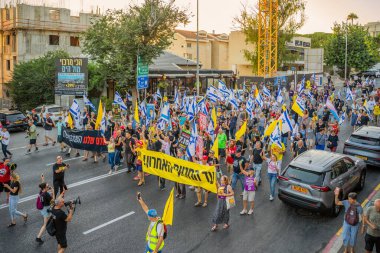 Hayfa, İsrail - Temmuz 05, 2025: Çeşitli tabela ve bayraklara sahip insanlar, savaşın sona ermesi, rehine anlaşmasının tamamlanması ve yeni seçimlerin başlatılması için düzenlenen protesto mitingine katıldılar. Hayfa, İsrail
