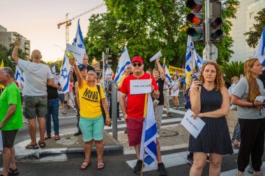 Hayfa, İsrail - 5 Temmuz 2025: Tabelalı kalabalık: Şimdi herkes (rehineleri geri getirsin) ve diğer işaretler ve bayraklar, Hayfa, İsrail 'de düzenlenen bir protesto mitingine katıldılar.