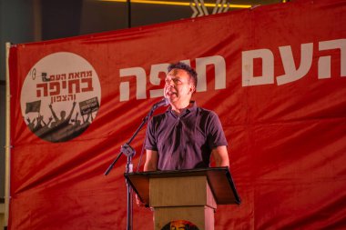 Hayfa, İsrail - Temmuz 05, 2025: MK Vladimir Beliak, savaşın sona ermesi, rehine anlaşmasının tamamlanması ve yeni seçimler için düzenlenen protesto mitinginin bir parçası olarak kalabalığa seslendi. Hayfa, İsrail