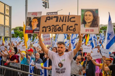 Hayfa, İsrail - 5 Temmuz 2025: Tabelalı kalabalık: Şimdi herkes (rehineleri geri getirsin) ve diğer işaretler ve bayraklar, Hayfa, İsrail 'de düzenlenen bir protesto mitingine katıldılar.