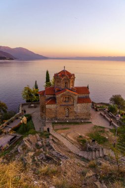 Ohri, Kuzey Makedonya - 03 Ekim 2023: Eski Makedonya 'nın Ohri kentindeki Aziz John Kilisesi' nin ziyaretçilerle birlikte gün batımı manzarası