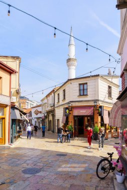 Üsküp, Kuzey Makedonya - 05 Ekim 2023: Eski Pazar semtinde dükkanlar, yerel halk ve ziyaretçilerin olduğu sokak manzarası. Üsküp, Kuzey Makedonya