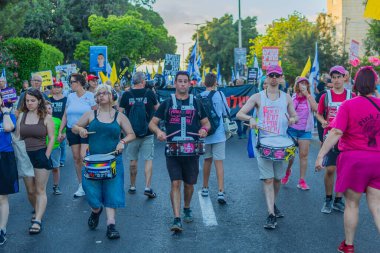 Hayfa, İsrail - 12 Temmuz 2025: İnsanlar savaşın sona ermesi, rehine anlaşmasının tamamlanması ve yeni seçimler çağrısında bulunan bir protesto yürüyüşüne (Pembe Cephe Grubu) katılıyor. Hayfa, İsrail