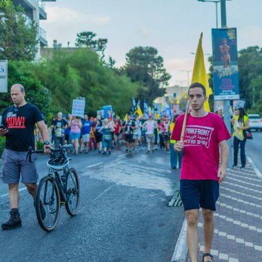 Hayfa, İsrail - 12 Temmuz 2025: İnsanlar savaşın sona ermesi, rehine anlaşmasının tamamlanması ve yeni seçimler çağrısında bulunan bir protesto yürüyüşüne (Pembe Cephe Grubu) katılıyor. Hayfa, İsrail