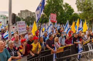 Hayfa, İsrail - 12 Temmuz 2025: Çeşitli tabela ve bayraklara sahip bir grup insan, savaşın sona ermesi, rehine anlaşmasının tamamlanması ve yeni seçimler için düzenlenen protesto mitingine katıldı. Hayfa, İsrail
