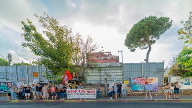 Hayfa, İsrail - 19 Temmuz 2025: İnsanlar çeşitli işaret ve bayraklarla bir protesto yürüyüşüne katılıyor, savaşın sona ermesi ve rehine anlaşmasının tamamlanması çağrısında bulunuyorlar. Hayfa, İsrail