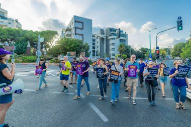 Hayfa, İsrail - 19 Temmuz 2025: İnsanlar savaşın sona ermesi, rehine anlaşmasının tamamlanması ve yeni seçimler çağrısında bulunan bir protesto yürüyüşüne katılıyor. Hayfa, İsrail