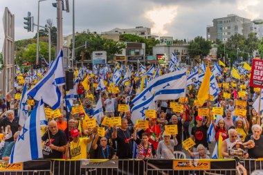 Hayfa, İsrail - 19 Temmuz 2025: Tabelalı kalabalık: Neden hala Gazze 'de rehineler ve diğer işaretler ve bayraklar var, Hayfa, İsrail' de düzenlenen bir protesto mitinginde yer alıyorlar?