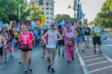 Hayfa, İsrail - 26 Temmuz 2025: İnsanlar savaşın sona ermesi, rehine anlaşmasının tamamlanması ve yeni seçimler çağrısında bulunan bir protesto yürüyüşüne (Pembe Cephe Grubu) katılıyor. Hayfa, İsrail