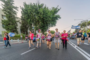 Hayfa, İsrail - 26 Temmuz 2025: İnsanlar savaşın sona ermesi, rehine anlaşmasının tamamlanması ve yeni seçimler çağrısında bulunan bir protesto yürüyüşüne (Pembe Cephe Grubu) katılıyor. Hayfa, İsrail