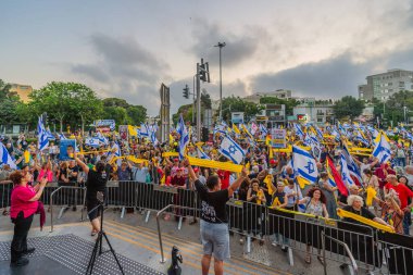 Hayfa, İsrail - 26 Temmuz 2025: Sarı kurdele ve diğer işaret ve bayraklar taşıyan kalabalık, protesto mitinginde yer alarak Hayfa, İsrail 'deki rehine anlaşmasının tamamlanması yönünde çağrıda bulundu