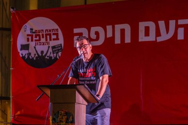Hayfa, İsrail - 26 Temmuz 2025: Ofer Shor, savaşın sona ermesi, rehine anlaşmasının tamamlanması ve yeni seçimler için düzenlenen protesto mitinginin bir parçası olarak kalabalığa sesleniyor. Hayfa, İsrail