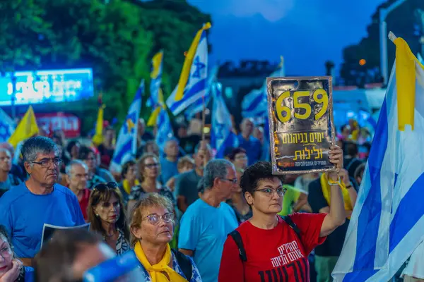 Hayfa, İsrail - 26 Temmuz 2025: Çeşitli tabela ve bayraklara sahip bir grup insan, savaşın sona ermesi, rehine anlaşmasının tamamlanması ve yeni seçimler için düzenlenen protesto mitingine katıldı. Hayfa, İsrail
