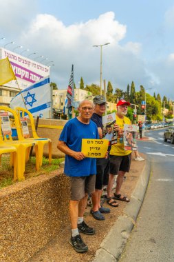 Hayfa, İsrail - 31 Temmuz 2025: Tabela ve bayraklı insanların günlük protesto gösterileri, rehineleri desteklemek ve anlaşmanın Hayfa, İsrail 'de tamamlanması yönünde çağrıda bulunmaları