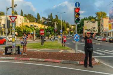 Hayfa, İsrail - 31 Temmuz 2025: Tabela ve bayraklı insanların günlük protesto gösterileri, rehineleri desteklemek ve anlaşmanın Hayfa, İsrail 'de tamamlanması yönünde çağrıda bulunmaları