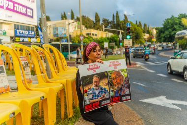 Hayfa, İsrail - 31 Temmuz 2025: Tabela ve bayraklı insanların günlük protesto gösterileri, rehineleri desteklemek ve anlaşmanın Hayfa, İsrail 'de tamamlanması yönünde çağrıda bulunmaları