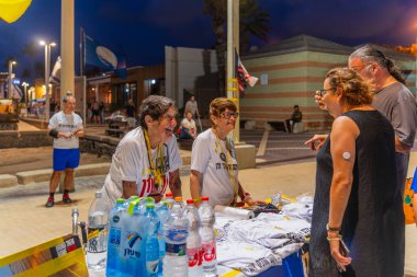 Hayfa, İsrail - 31 Temmuz 2025: Gönüllüler, savaşın 650 'nci gününde İsrail' in Hayfa plajında rehinelerin serbest bırakılması çağrısında bulunarak sosyal bir etkinlikte durdular.