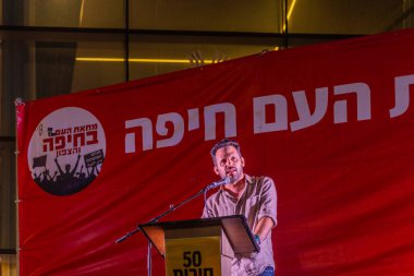 Hayfa, İsrail - 2 Ağustos 2025: Ido Dembin, savaşın sona ermesi, rehine anlaşmasının tamamlanması ve yeni seçimler için düzenlenen protesto mitinginin bir parçası olarak kalabalığa seslendi. Hayfa, İsrail