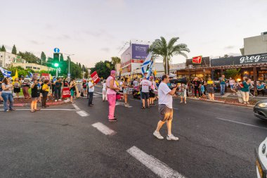 Hayfa, İsrail - 07 Ağustos 2025: İnsanlar yolu kapatıyor, gece protestolarının bir parçası olarak, hükümeti savaşı uzatmamaya ve rehine anlaşmasının tamamlanmasına çağırıyorlar. Hayfa, İsrail