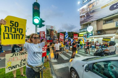 Hayfa, İsrail - 07 Ağustos 2025: İnsanlar yolu kapatıyor, gece protestolarının bir parçası olarak, hükümeti savaşı uzatmamaya ve rehine anlaşmasının tamamlanmasına çağırıyorlar. Hayfa, İsrail