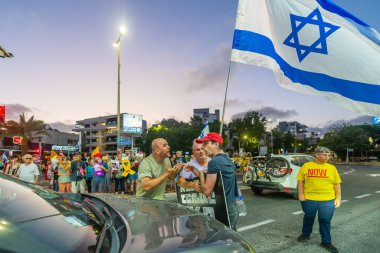 Hayfa, İsrail - 07 Ağustos 2025: Sürücü, gece protestosu kapsamında yolu kapatan insanlarla yüzleşerek hükümeti savaşı uzatmamaya çağırdı. Hayfa, İsrail