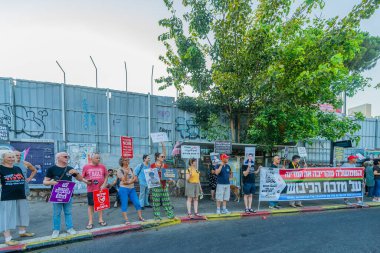 Hayfa, İsrail - 09 Ağustos 2025: İnsanlar çeşitli işaret ve bayraklarla bir protesto yürüyüşüne katılıyor, savaşı sona erdirme ve rehine anlaşmasının tamamlanması çağrısında bulunuyorlar. Hayfa, İsrail