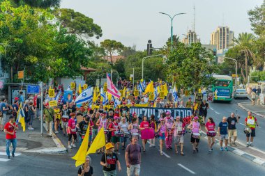 Hayfa, İsrail - 09 Ağustos 2025: Çeşitli tabelaları ve bayrakları olan insanlar, savaşın sona ermesi, rehine anlaşmasının tamamlanması ve yeni seçimlerin başlatılması için düzenlenen protesto mitingine katıldılar. Hayfa, İsrail
